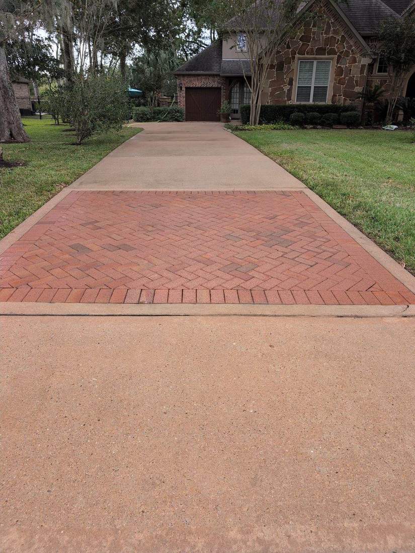 Driveway after softwashing with paver inlay revealed